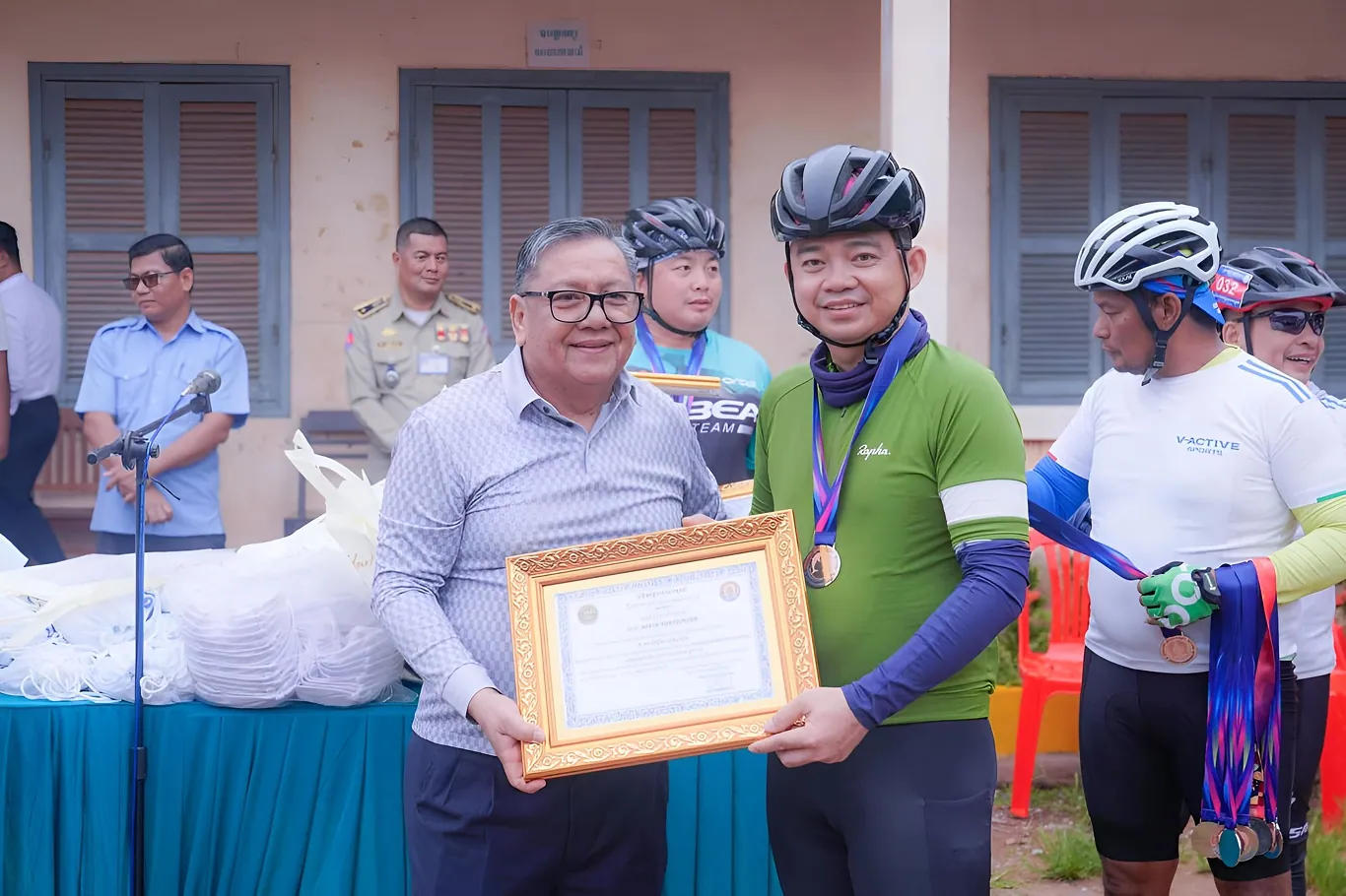 TB Insurance Broker presenting a certificate at a community cycling event