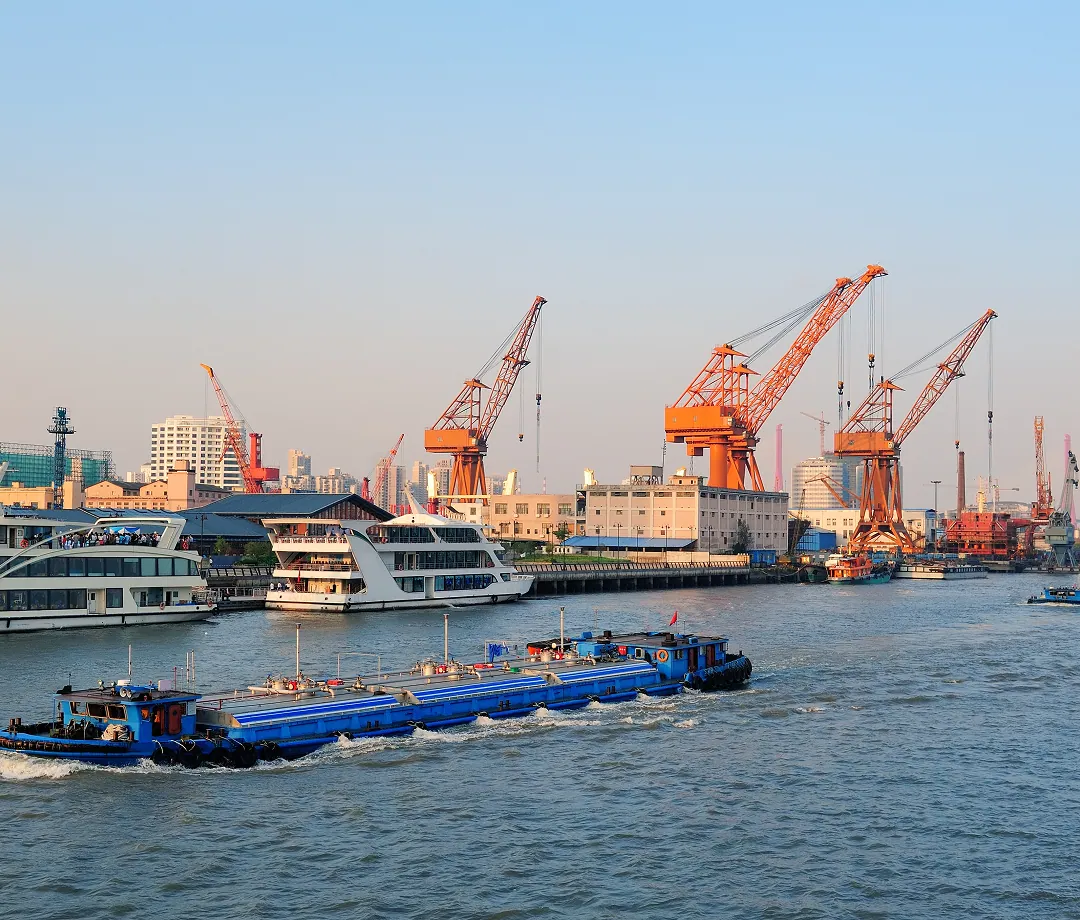 Cargo barge and cranes at a busy port