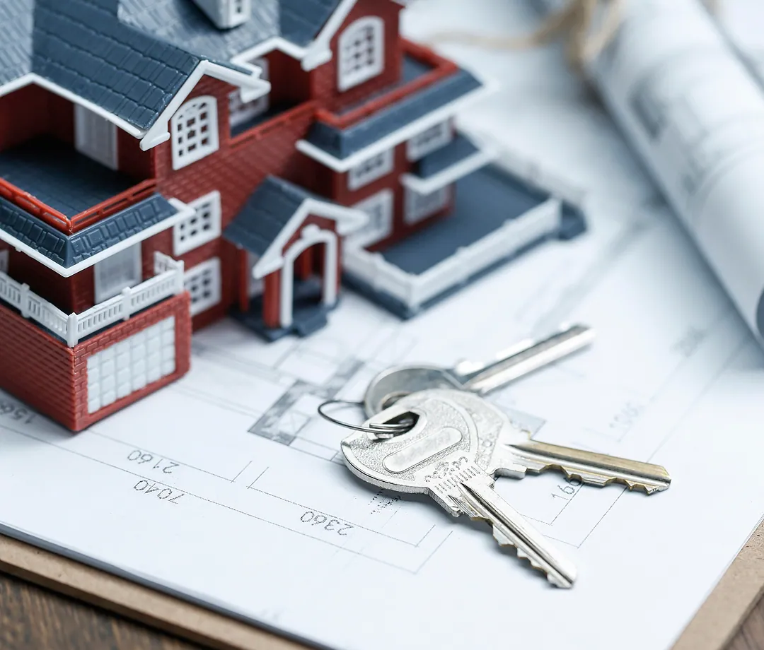 House model and keys on a floor plan
